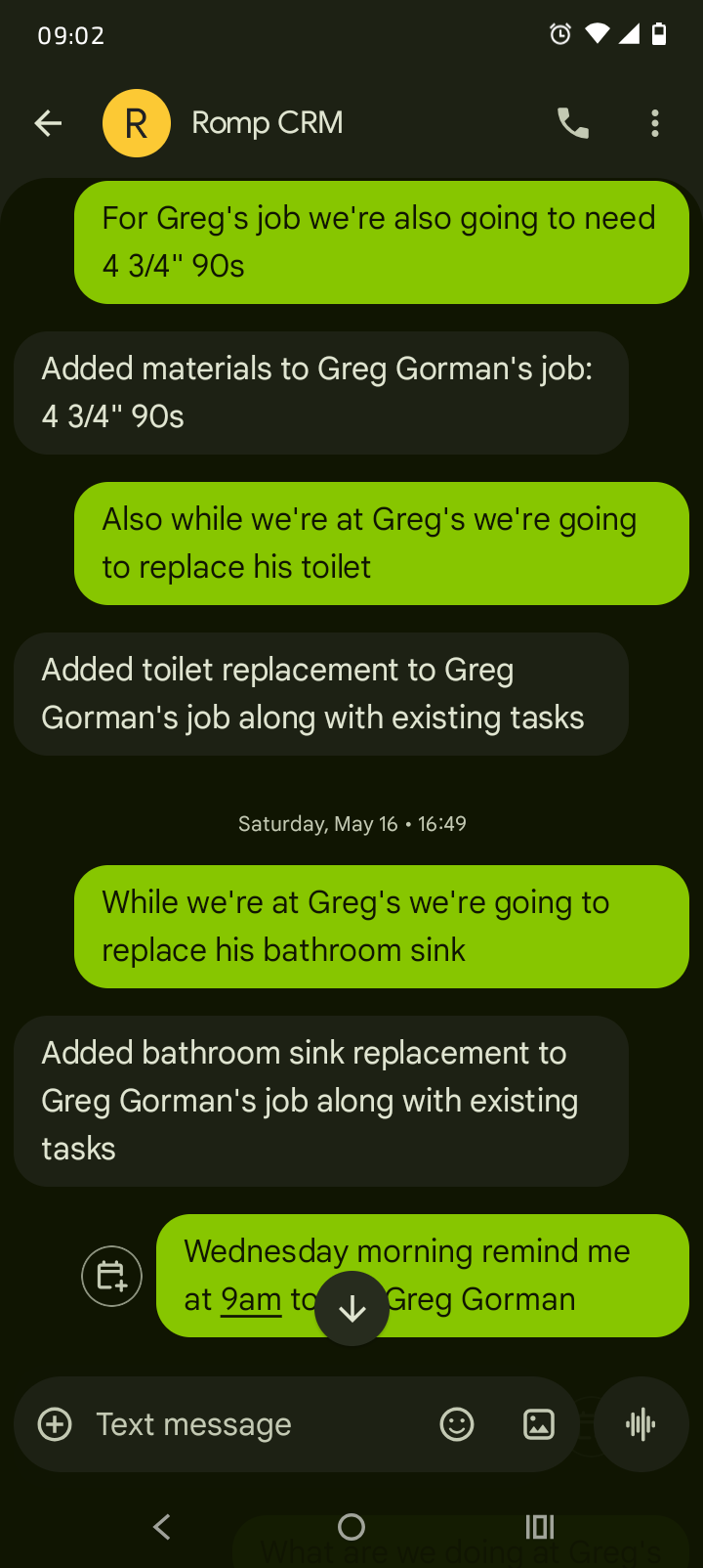 Mobile screenshot of a text conversation where a user adds materials, toilet replacement, and sink replacement tasks to Greg Gorman's job by text.